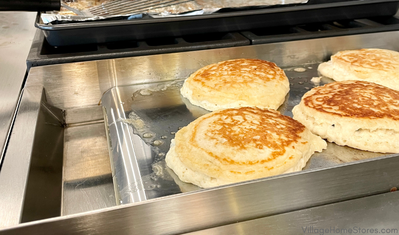 shiny chrome cooktop griddle with pancakes on it